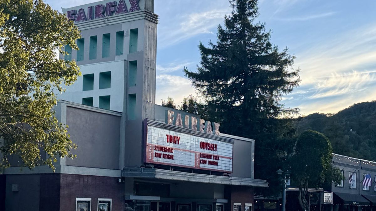 The Fairfax Theatre at dusk, its art deco tower and lit marquee over Broadway.